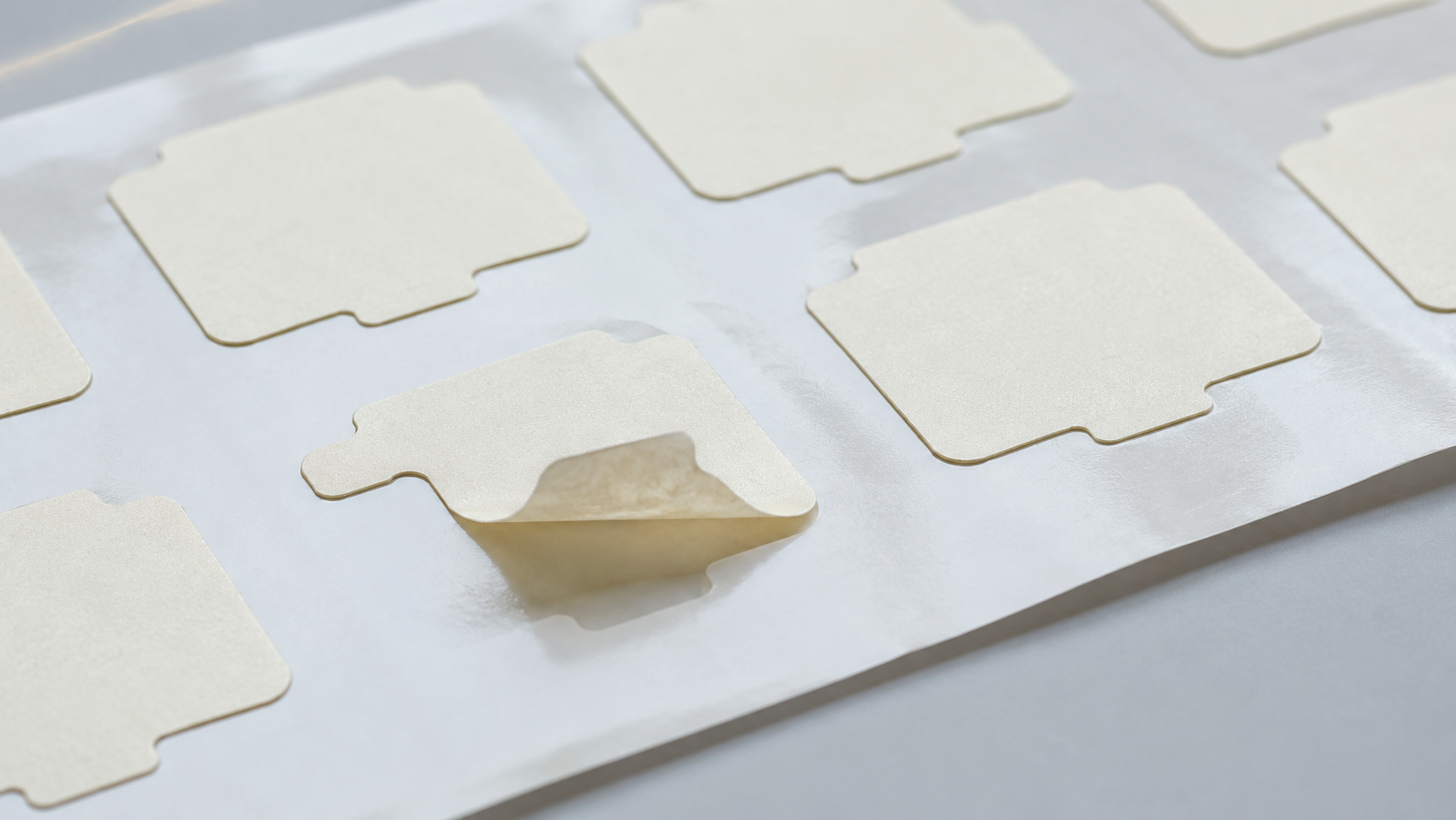 Kiss-cut adhesive die-cut components supported on release liner during production sample validation