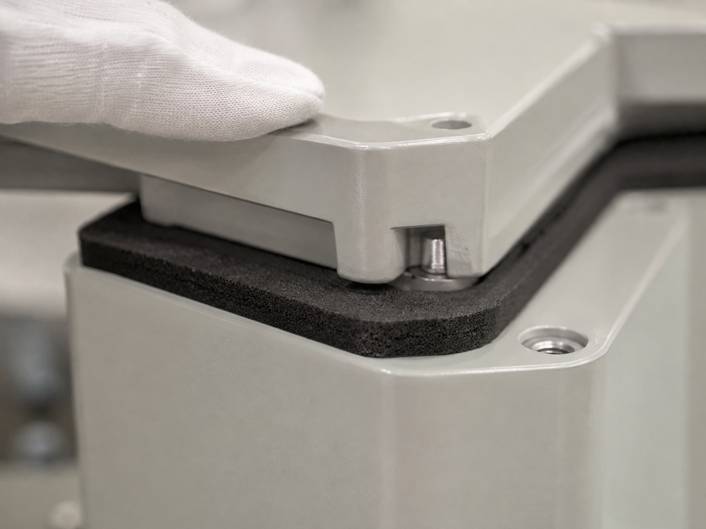 Controlled compression of an adhesive-backed foam gasket