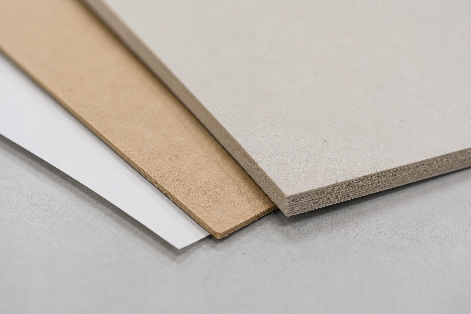 Close view comparing thin coated paper, kraft paper and thick paperboard edges