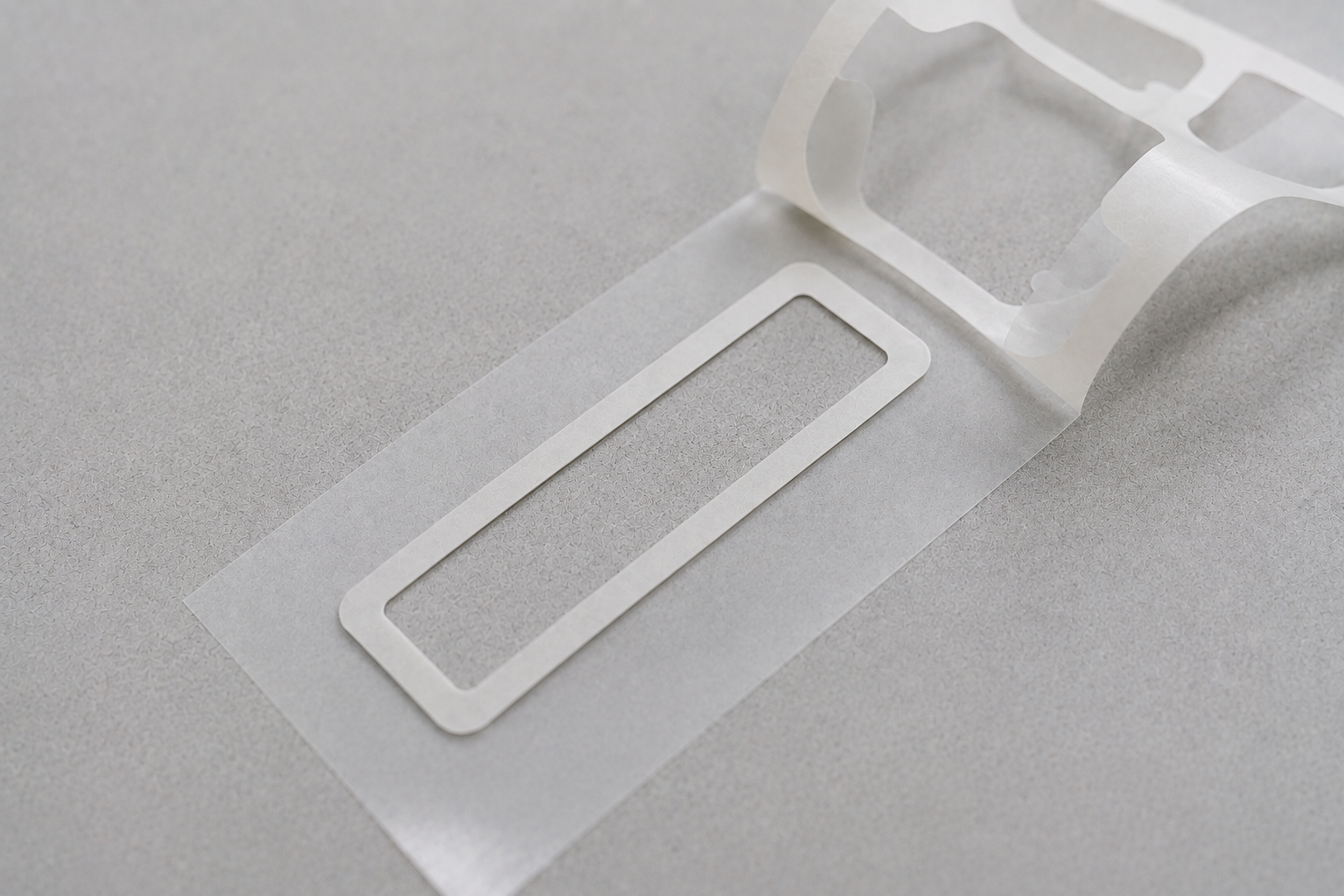 Kiss-cut adhesive tape frame retained on release liner after waste removal
