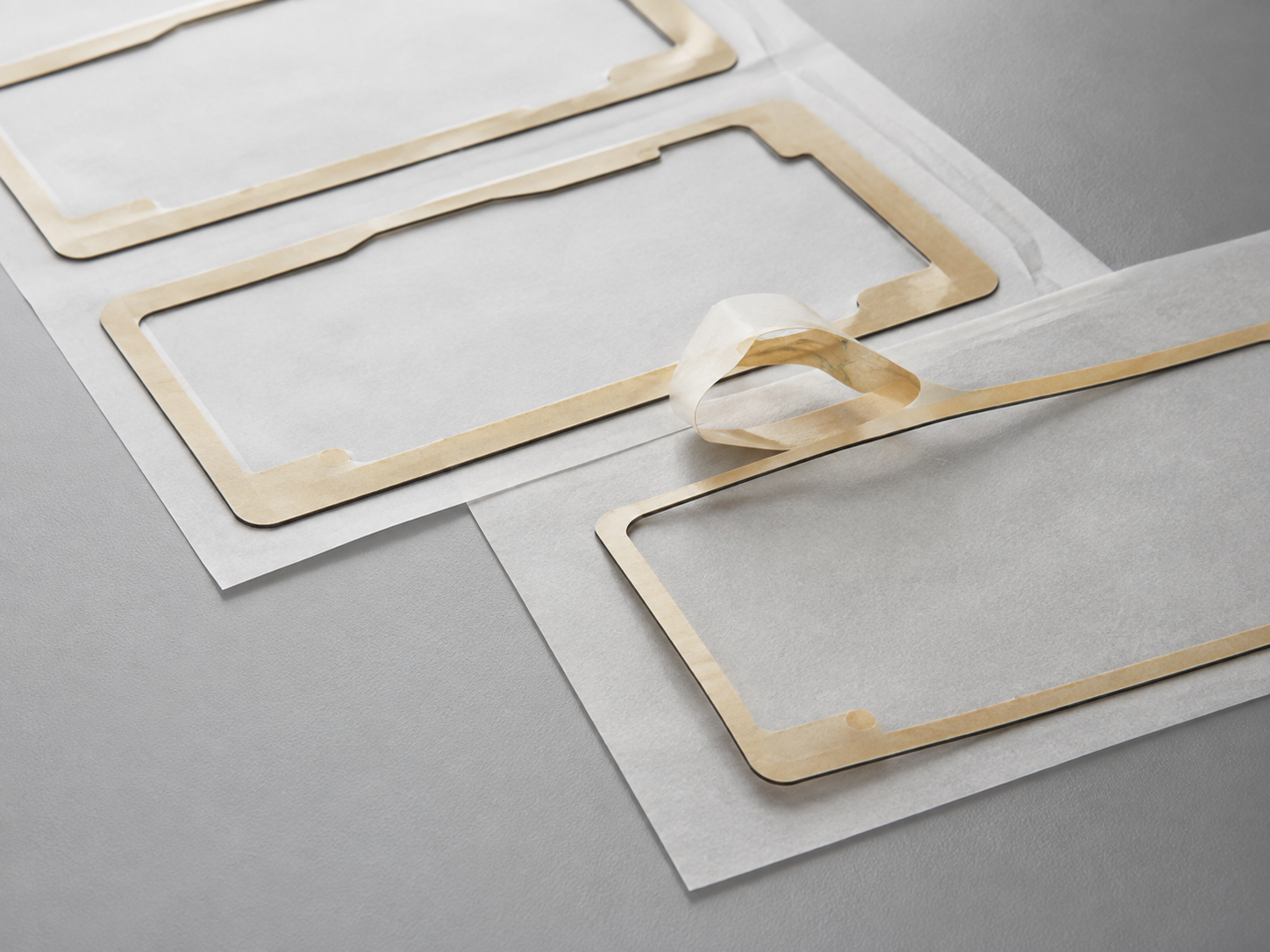 Die-cut adhesive tape for display modules with clean perimeter frames on release liners
